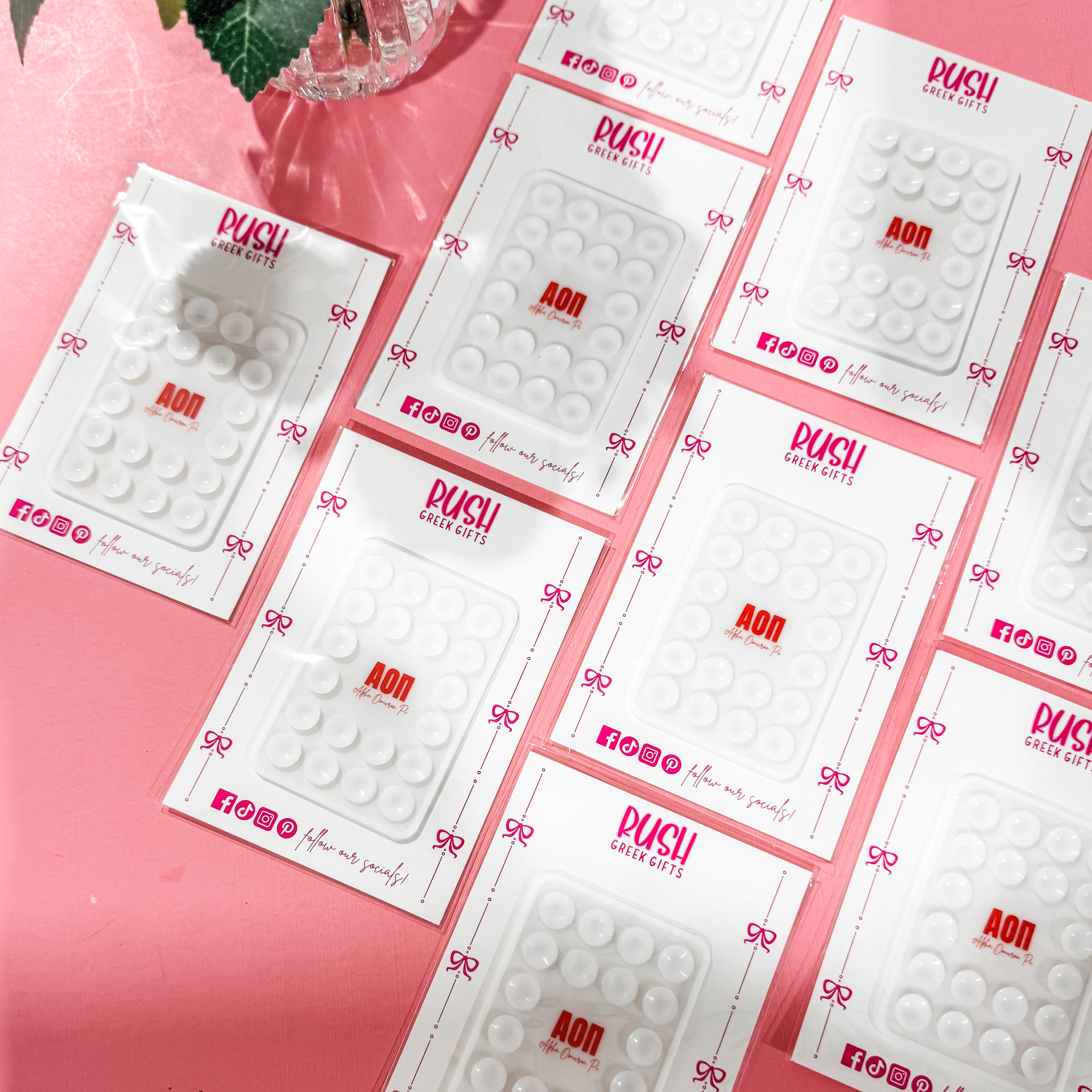 Multiple packages of a suction phone accessory for the Alpha Omicron Pi sorority.