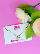 Sorority Greek charm necklace on a card with flowers on a pink background